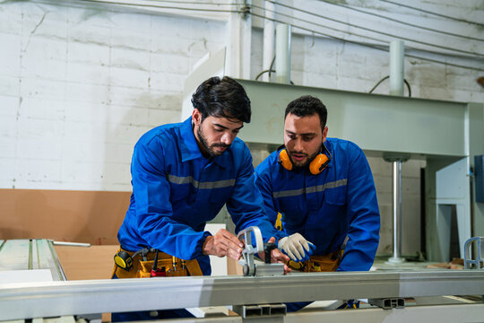 Modern industrial machine operator working in industrial factory. Woodworking carpenter furniture hand cutting.