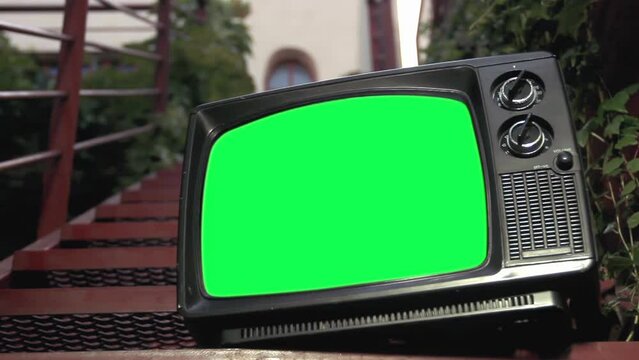 Old Television Green Screen on Outdoor Staircase. Close Up. You can replace green screen with the footage or picture you want with “Keying” effect in After Effects. 4K.