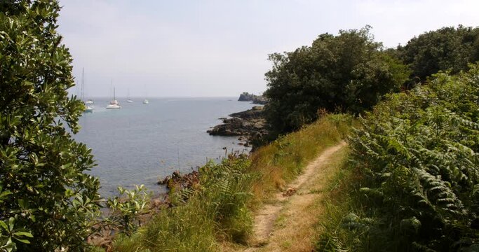 Wide shot of coastal path with foliage on the island of St Agnes at the Isles of Scilly.