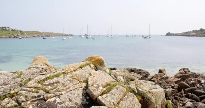wide shot of the natural harbour, on St Agnes and Gugh at the Isles of Scilly. rocks in foreground.