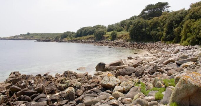 Extra wide shot waves lapping on the rocky shore at St Agnes at the Isles of Scilly