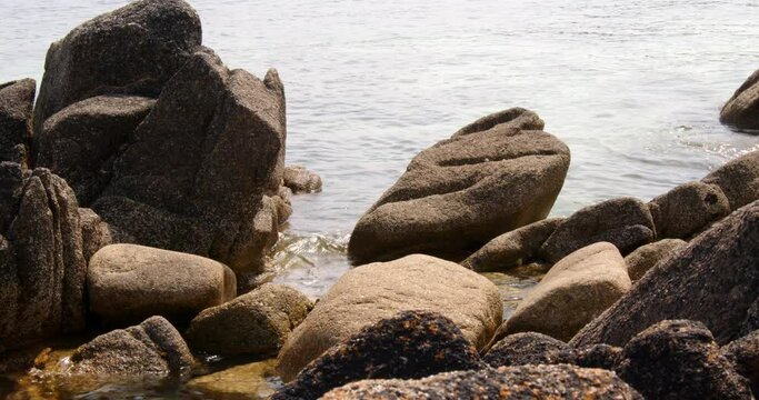 a series of eroded rocks and the sea lapping around then on the beach on St Agnes at the Isles of Scilly 4 of 6