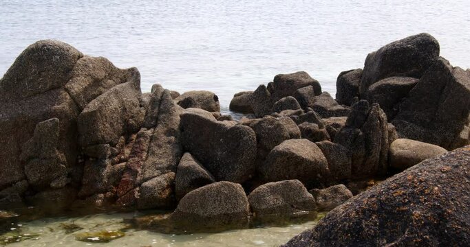 a series of eroded rocks and the sea lapping around then on the beach on St Agnes at the Isles of Scilly 3 of 6
