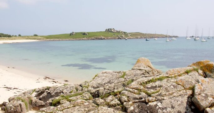 wide shot of the natural harbour, on St Agnes and Gugh at the Isles of Scilly. rocks in foreground and Gugh in background