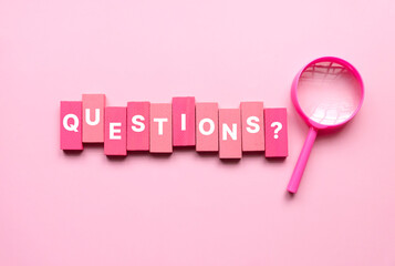 QnA or questions and answers concept. Pink magnifying glass with text over a pink background.