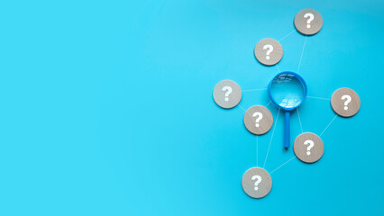 QnA or questions and answers concept. Pink magnifying glass with question symbol over a blue background with copy space. - obrazy, fototapety, plakaty