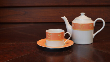 Teapot set as seen from above on a dark wood dining room table.