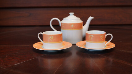 Teapot set as seen from above on a dark wood dining room table.