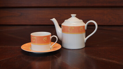 Teapot set as seen from above on a dark wood dining room table.
