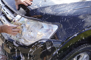 man washing car with car wash - pressure washer , shampoo, sponges and microfiber car towels