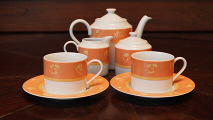 Obraz premium Teapot set as seen from above on a dark wood dining room table.