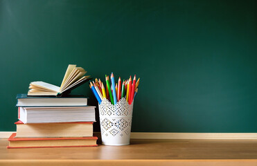 books and school stationery on table, chalkboard background. beginning of the school year, teacher's day. Knowledge Day, education concept. back to school . Copy space. template for design © Ju_see