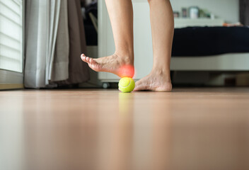 Woman massage with tennis ball on foot,Feet soles massage for plantar fasciitis - obrazy, fototapety, plakaty
