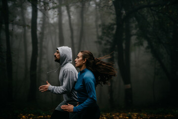 Front view of joggers sprinting through the fog, capturing the essence of movement and mystery.