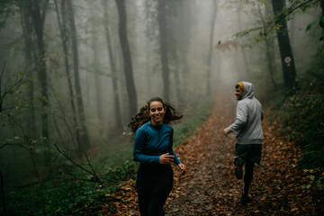  Two friends in stylish activewear jog together, their camaraderie illuminated by the mist.