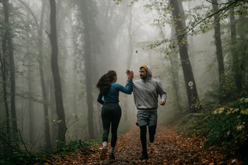  Two friends in stylish activewear jog together, their camaraderie illuminated by the mist.