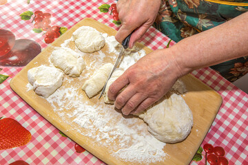 The baker cuts pieces of dough for baking pies
