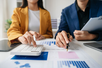 The business team analyzes revenue charts and graphs with laptop and tablet.Business analysis