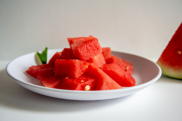 Freshly sliced watermelon on a white plate with a wood pattern background