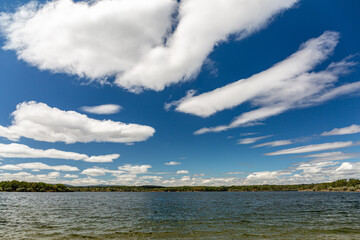 Natural landscape with the waters of the Valparaíso Reservoir, riverbank with trees and blue sky with clouds, Zamora, Spain.