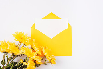 Yellow envelope with blank card and flowers on white background. Birthday, invitation, holiday...