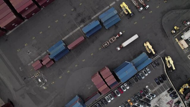 Overhead of trucks and intermodal containers in an industrial shipping yard.