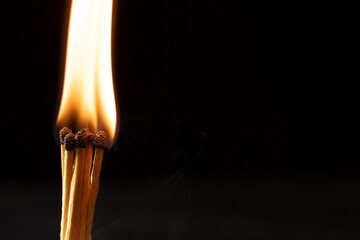 Close up of lit matches with copy space on black background
