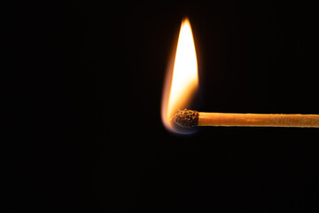 Close up of lit match with copy space on black background