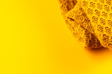 Micro close up of yellow wooly crochet fabric with copy space on yellow background