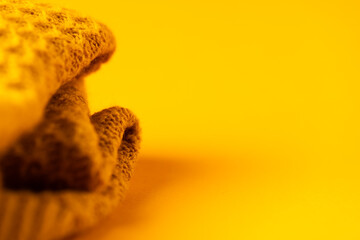 Micro close up of yellow wooly crochet fabric with copy space on yellow background