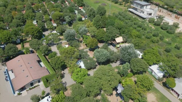 Lush green trees provide cool shade for campers at cisano San Vito lake garda, Italy
