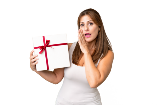 Middle age caucasian woman holding a gift over isolated background whispering something