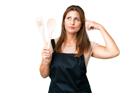 Middle age caucasian woman holding a rolling pin over isolated background having doubts and thinking