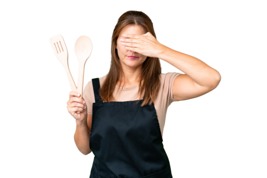 Middle age caucasian woman holding a rolling pin over isolated background covering eyes by hands. Do not want to see something