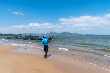 A man in sun clothes is fishing on the beach in south china. Beautiful scenery of Shigongliao Village, Shanwei city.