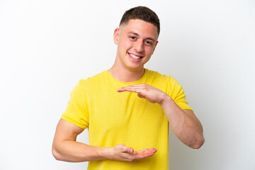 Young brazilian man isolated on white background holding copyspace imaginary on the palm to insert...