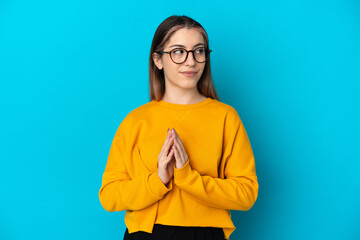 Young caucasian woman isolated on blue background scheming something