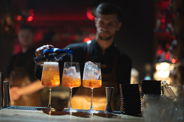 the bartender prepares a beautiful alcoholic cocktail at the bar counter