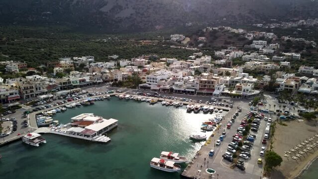 Sunlight reflected in the marina of Elounda at the island Crete with the high mountains in the background. Backwards drone dolley shot