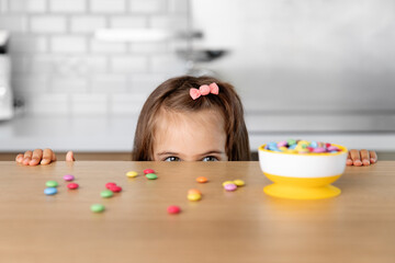 Young girl looking at candy on kitchen table