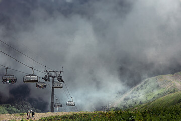 Obraz premium Cabins of cable car funicular in thick white fog.
