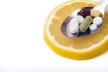 a slice of lemon on a white background,a teaspoon of medicine on a lemon,the concept of the choice of treatment