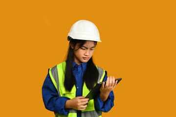 Smiling Asian girl wearing helmet holding laptop isolated on yellow background, future dream job career as engineer and architect