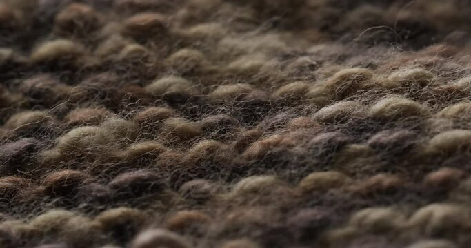 Micro video of close up of brown knitted wooly fabric with copy space