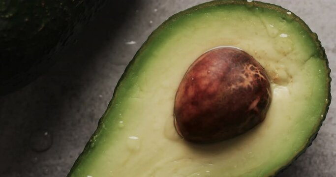 Micro video of close up of avocado with copy space on grey background