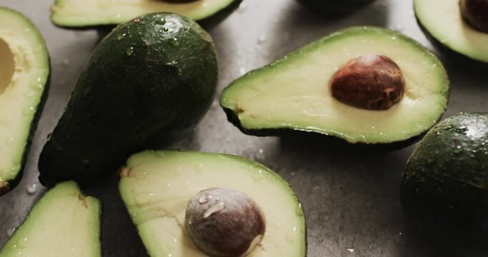 Micro video of close up of avocados with copy space on grey background