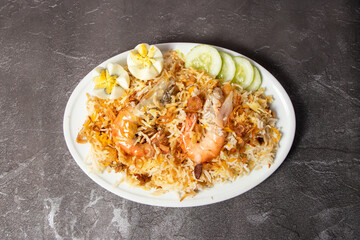 Shrimp Biryani pulao rice with cucumber served in dish isolated on background top view of bangladesh food