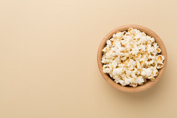 Tasty popcorn in bowl on color background