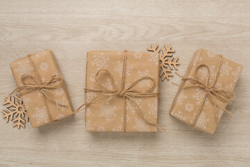Craft christmas gift boxes on wooden background, top view