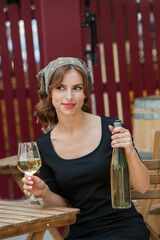 Beautiful young woman drinking white wine on the terrace of a restaurant